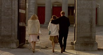 Movie still from “Breakfast on Pluto” (2005), directed by Neil Jordan – Three people walking down a street with a baby stroller; Wide shot, Low angle