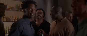 Movie still from “Breakin' All the Rules” (2004), directed by Daniel Taplitz – A group of men standing next to each other in a room; Medium shot, Over the shoulder angle