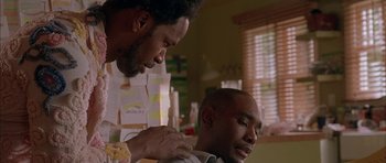 Movie still from “Breakin' All the Rules” (2004), directed by Daniel Taplitz – A man getting his hair combed by another man; Close Up shot, Low angle