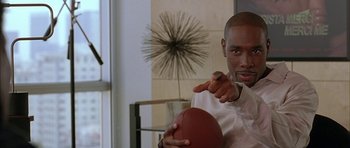 Movie still from “Breakin' All the Rules” (2004), directed by Daniel Taplitz – A man holding a football and pointing to the camera; Close Up shot, Low angle