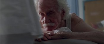 Movie still from “Breakin' All the Rules” (2004), directed by Daniel Taplitz – An old man with white hair and a white beard laying on a bed; Close Up shot, High angle