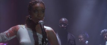 Movie still from “Breakin' All the Rules” (2004), directed by Daniel Taplitz – A woman standing next to a man holding a microphone; Medium shot, Over the shoulder angle