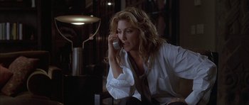Movie still from “Breakin' All the Rules” (2004), directed by Daniel Taplitz – A woman talking on a cell phone while sitting at a table; Medium shot, Low angle
