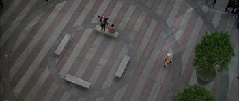 Movie still from “Breakin' All the Rules” (2004), directed by Daniel Taplitz – An aerial view of a person standing on a bench; Extreme Wide shot, Overhead angle