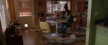 Movie still from “Breakin' All the Rules” (2004), directed by Daniel Taplitz – A man sitting at a table in front of a window; Wide shot, High angle