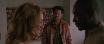 Movie still from “Breakin' All the Rules” (2004), directed by Daniel Taplitz – A man in a brown jacket standing next to a woman in a green shirt; Close Up shot, Over the shoulder angle
