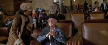 Movie still from “Breakin' All the Rules” (2004), directed by Daniel Taplitz – An older man sitting in a chair with a hat on; Medium shot, High angle