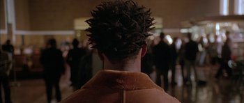 Movie still from “Breakin' All the Rules” (2004), directed by Daniel Taplitz – A man with a brown jacket and a bunch of hair; Close Up shot, Over the shoulder angle