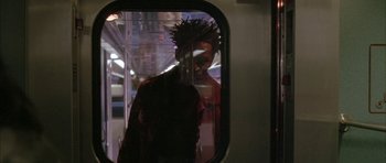Movie still from “Breakin' All the Rules” (2004), directed by Daniel Taplitz – A man is seen through a window on a train; Medium shot, Over the shoulder angle