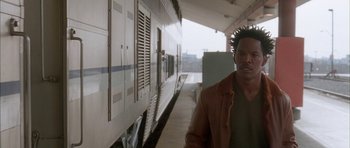 Movie still from “Breakin' All the Rules” (2004), directed by Daniel Taplitz – A man standing in front of a train on a train platform; Close Up shot, Over the shoulder angle