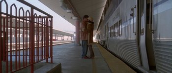 Movie still from “Breakin' All the Rules” (2004), directed by Daniel Taplitz – A man and a woman kissing in front of a train; Wide shot, Low angle
