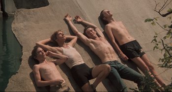 Movie still from “Breaking Away” (1979), directed by Peter Yates – A group of young men laying on the ground together; Medium shot, Overhead angle