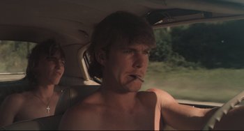 Movie still from “Breaking Away” (1979), directed by Peter Yates – A man sitting in the back seat of a car smoking a cigarette; Close Up shot, Low angle