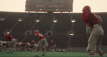 Movie still from “Breaking Away” (1979), directed by Peter Yates – A group of football players are on the field; Extreme Wide shot, High angle