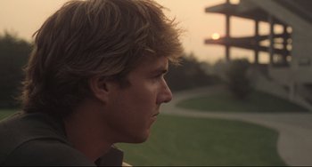 Movie still from “Breaking Away” (1979), directed by Peter Yates – A young man looking into the distance in a park; Close Up shot, Low angle