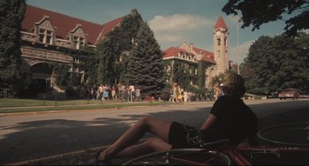 Movie still from “Breaking Away” (1979), directed by Peter Yates – A woman sitting on the ground next to a bicycle; Extreme Wide shot, High angle
