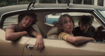 Movie still from “Breaking Away” (1979), directed by Peter Yates – Three young people in the back seat of a car; Medium shot, Low angle