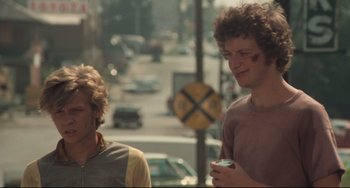 Movie still from “Breaking Away” (1979), directed by Peter Yates – Two young men standing next to each other on the street; Medium shot, Low angle