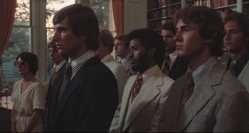Movie still from “Breaking Away” (1979), directed by Peter Yates – A group of men in suits and ties in a room; Medium shot, Low angle