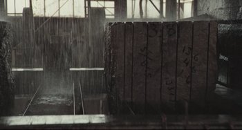 Movie still from “Breaking Away” (1979), directed by Peter Yates – A large concrete block in the middle of a building; Extreme Wide shot, Over the shoulder angle