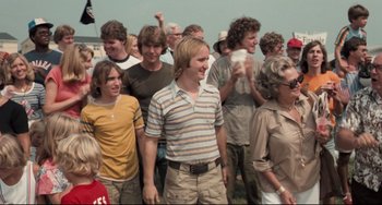 Movie still from “Breaking Away” (1979), directed by Peter Yates – A group of people standing in a field; Medium shot, Over the shoulder angle