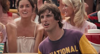 Movie still from “Breaking Away” (1979), directed by Peter Yates – A young man with long brown hair and a purple and yellow shirt; Close Up shot, Low angle