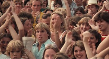Movie still from “Breaking Away” (1979), directed by Peter Yates – A group of people standing next to each other in a crowd; Medium shot, High angle