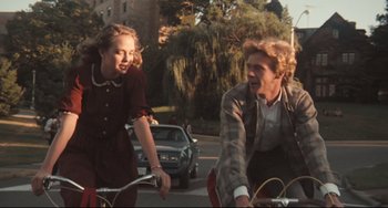 Movie still from “Breaking Away” (1979), directed by Peter Yates – A man and a woman riding bikes down a street; Medium shot, Low angle