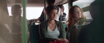 Movie still from “Breathe” (2014), directed by Mélanie Laurent – A woman sitting on top of a green bus; Medium shot, Over the shoulder angle
