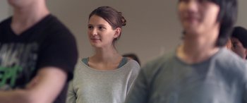 Movie still from “Breathe” (2014), directed by Mélanie Laurent – A young woman is standing in front of a group of people; Close Up shot, Over the shoulder angle