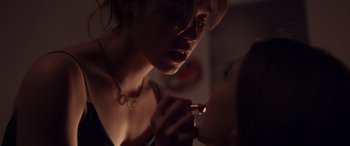 Movie still from “Breathe” (2014), directed by Mélanie Laurent – A woman is putting lipstick on her lips; Extreme Close Up shot, Over the shoulder angle