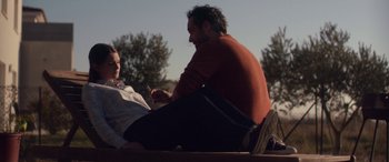 Movie still from “Breathe” (2014), directed by Mélanie Laurent – A man and a woman sitting on the ground talking; Medium shot, Over the shoulder angle