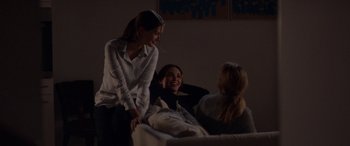 Movie still from “Breathe” (2014), directed by Mélanie Laurent – Three people are sitting in a room and one is laughing; Medium shot, Over the shoulder angle
