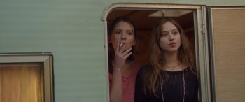 Movie still from “Breathe” (2014), directed by Mélanie Laurent – Two young women are standing in the doorway of an rv; Medium shot, Low angle