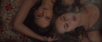 Movie still from “Breathe” (2014), directed by Mélanie Laurent – Two young women laying on top of each other; Close Up shot, Overhead angle