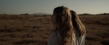 Movie still from “Breathe” (2014), directed by Mélanie Laurent – Two women standing in the middle of an open field; Medium shot, Over the shoulder angle