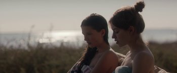 Movie still from “Breathe” (2014), directed by Mélanie Laurent – Two young women standing next to each other on the beach; Close Up shot, Over the shoulder angle
