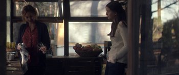 Movie still from “Breathe” (2014), directed by Mélanie Laurent – A woman standing in front of a basket of fruit; Medium shot, Over the shoulder angle