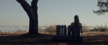 Movie still from “Breathe” (2014), directed by Mélanie Laurent – A person sitting on a bench near a tree; Extreme Wide shot, Over the shoulder angle