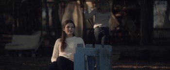 Movie still from “Breathe” (2014), directed by Mélanie Laurent – A woman sitting on top of a wooden bench; Medium shot, Over the shoulder angle