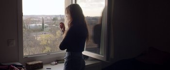 Movie still from “Breathe” (2014), directed by Mélanie Laurent – A woman standing in front of a window looking outside; Medium shot, Over the shoulder angle