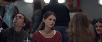 Movie still from “Breathe” (2014), directed by Mélanie Laurent – A woman in a red shirt is looking at the camera; Close Up shot, Over the shoulder angle