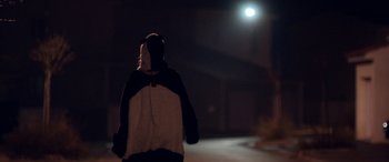 Movie still from “Breathe” (2014), directed by Mélanie Laurent – A person wearing a panda bear hoodie walking down a street; Medium shot, Over the shoulder angle