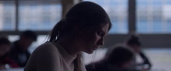 Movie still from “Breathe” (2014), directed by Mélanie Laurent – A woman with long dark hair sitting in a room; Close Up shot, Over the shoulder angle
