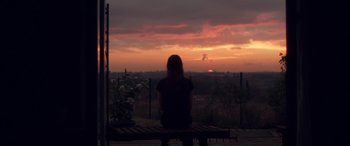 Movie still from “Breathe” (2014), directed by Mélanie Laurent – A woman sitting on a bench looking out at the sunset; Extreme Wide shot, Over the shoulder angle