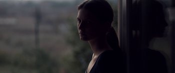 Movie still from “Breathe” (2014), directed by Mélanie Laurent – A woman standing in front of a window looking out of the window; Close Up shot, Over the shoulder angle