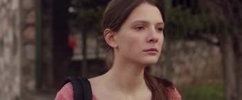 Movie still from “Breathe” (2014), directed by Mélanie Laurent – A young woman with long brown hair wearing a backpack; Close Up shot, Over the shoulder angle