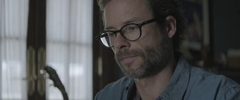 Movie still from “Breathe In” (2013), directed by Drake Doremus – A person wearing glasses; Close Up shot, Over the shoulder angle