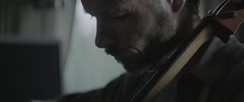 Movie still from “Breathe In” (2013), directed by Drake Doremus – A person holding a violin; Extreme Close Up shot, Low angle