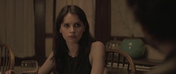 Movie still from “Breathe In” (2013), directed by Drake Doremus – A woman sitting at a table in front of a window; Close Up shot, Over the shoulder angle